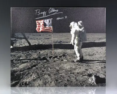 Iconic photograph on canvas of Buzz Aldrin standing next to the United States flag planted atop the lunar surface during the Apollo 11 mission. Boldly signed “Buzz Aldrin Apollo XI”Iconic photograph on canvas of Buzz Aldrin standing next to the United States flag planted atop the lunar surface during the Apollo 11 mission. Boldly signed “Buzz Aldrin Apollo XI.”