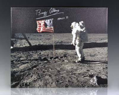 Iconic photograph on canvas of Buzz Aldrin standing next to the United States flag planted atop the lunar surface during the Apollo 11 mission. Boldly signed “Buzz Aldrin Apollo XI”Iconic photograph on canvas of Buzz Aldrin standing next to the United States flag planted atop the lunar surface during the Apollo 11 mission. Boldly signed “Buzz Aldrin Apollo XI.”