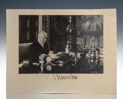 Photograph of a Man Sitting at an Ornate Desk
