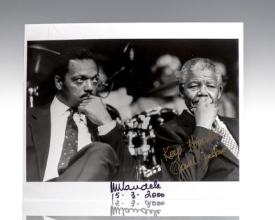 Black-and-white photograph of two men in suits seated side by side
